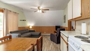 A compact kitchen with a stove, a dining table, and a ceiling fan. - Artilla Cove Resort #10 (Branson)