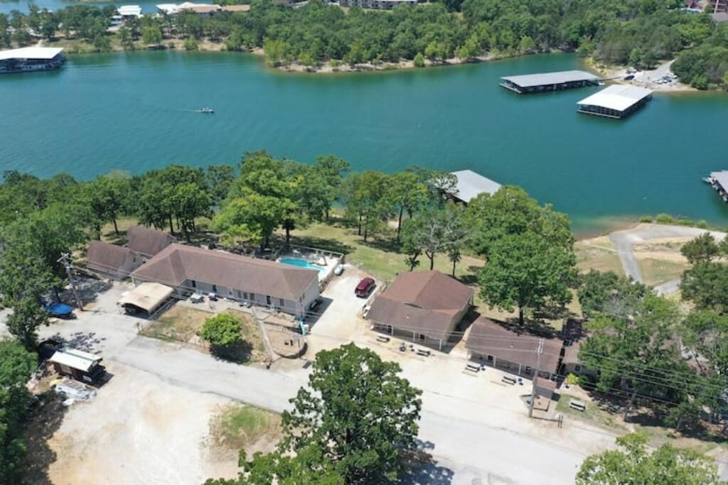 An aerial view of a residential area with houses, a swimming pool, and a dock.