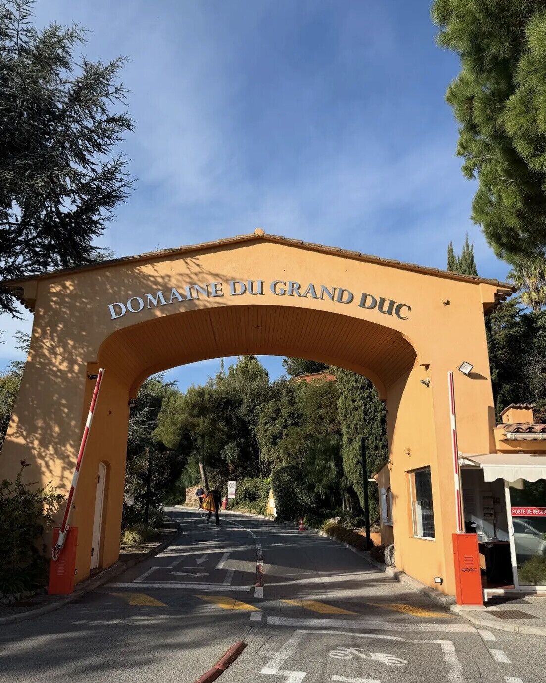 Un arc d’entrée portant l’inscription « DOMAINE DU GRAND DUC » mène à un espace de stationnement.