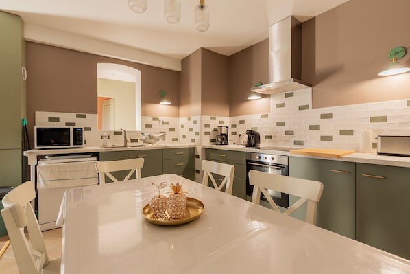 Une cuisine moderne avec une table à manger, des chaises et un four à micro-ondes.