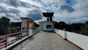 A rooftop terrace with a small building, a railing, and a clear sky. - Pring Pension House Puerto Princesa By Zuzu (Puerto Princesa)