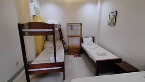 A small, clean room with two wooden bunk beds, a single bed, a wooden nightstand, and a small table. - Pring Pension House Puerto Princesa By Zuzu (Puerto Princesa)