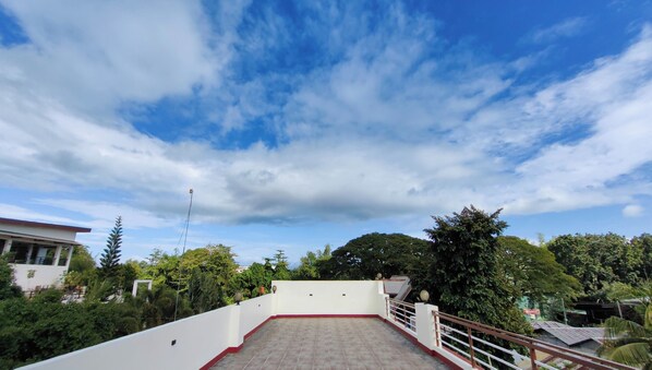 Une terrasse sur le toit offrant une vue dégagée sur le ciel et la végétation environnante.