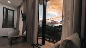 Ein modernes Wohnzimmer mit einer Couch, einer Bank und einem großen Fenster mit Blick auf den Himmel.