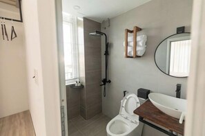 A modern bathroom with a shower, toilet, and sink. - THE ARIX House & Studio (Dalat)