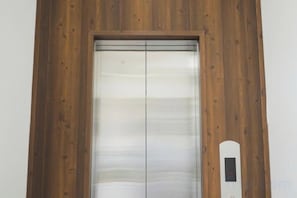 A wooden-framed elevator with a digital display. - THE ARIX House & Studio (Dalat)