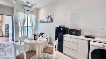 A modern kitchen with white cabinets, a black refrigerator, a microwave, and a dishwasher.
