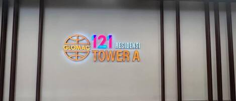 A wall with the text '121 Tower A' and a logo, indicating a hotel or residential building.