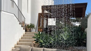 A modern outdoor area with a water feature, outdoor seating, and a staircase leading to an upper level. - Casa Bonic: Villa with Sunset - seaview and pool (Sant Josep de sa Talaia)