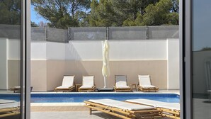 A modern outdoor pool area with lounge chairs and a pergola. - Casa Bonic: Villa with Sunset - seaview and pool (Sant Josep de sa Talaia)