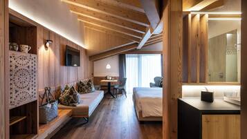 A wooden interior with a bed, a desk, and a bathroom visible through an open door.