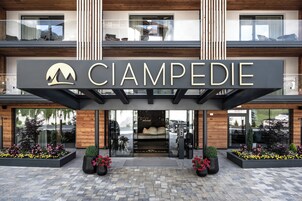 Entrada de hotel con un letrero llamativo que dice "CIAMPEDIE" y un logotipo de montaña.