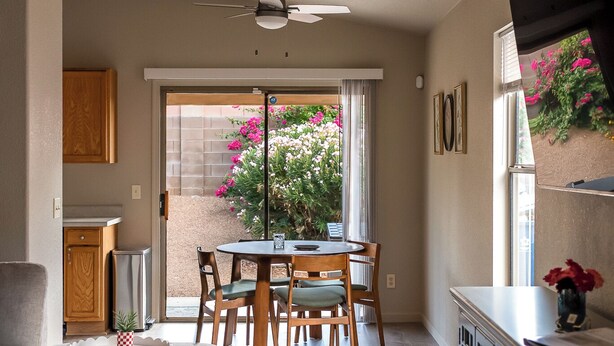 A spacious living area with a dining table, a sofa, and a ceiling fan. - Quiet Escape- Family Getaway by Trails and Shopping (Tucson)