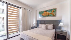 A modern bedroom with a large bed, two bedside tables, a window with blinds, and a painting on the wall. - Bright and Nice 3 Beds Close to 5th (Playa del Carmen)