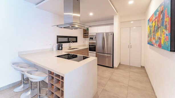 A modern kitchen with a central island, stainless steel appliances, and a minimalist design. - Bright and Nice 3 Beds Close to 5th (Playa del Carmen)