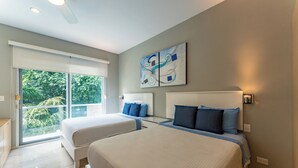 A modern bedroom with two beds, a sliding glass door to a balcony, and abstract wall art. - Bright and Stylish Ocean View Roof top Pool (Playa del Carmen)