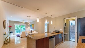 A modern kitchen with a central island, stainless steel appliances, and pendant lighting. - Bright and Stylish Ocean View Roof top Pool (Playa del Carmen)