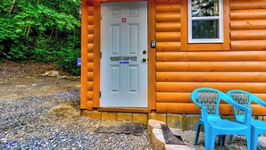A wooden cabin with a white door labeled "Squirrel Cabin Suite," a small window, and a number "3416" above the door. - Squirrel Cabin at Panther Creek (Cherokee)