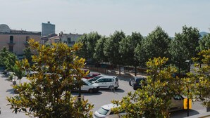 A parking lot with several cars, surrounded by trees and buildings. - Torre dels Bous Apartment 1-A (Hostalric)