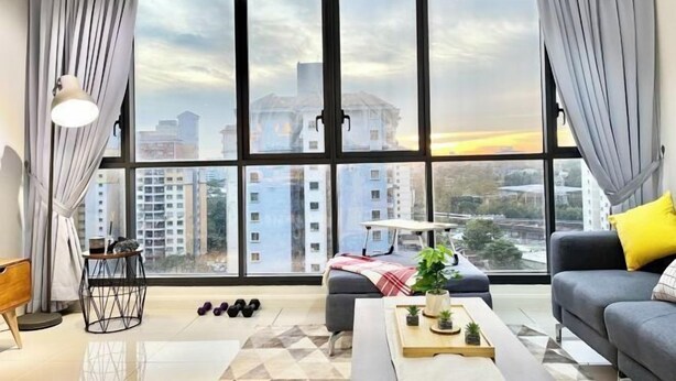 A modern living room with large windows, a sofa, a coffee table, and a small side table.