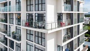 A multi-story building with balconies, large windows, and a modern architectural design. - Nha Cua Mang - CSJ Tower Bai Sau Vung Tau (Vung Tau)