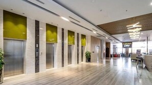 A modern hotel lobby with a marble floor, elevators, and a reception area with a sign reading "AURORA". - Nha Cua Mang - CSJ Tower Bai Sau Vung Tau (Vung Tau)