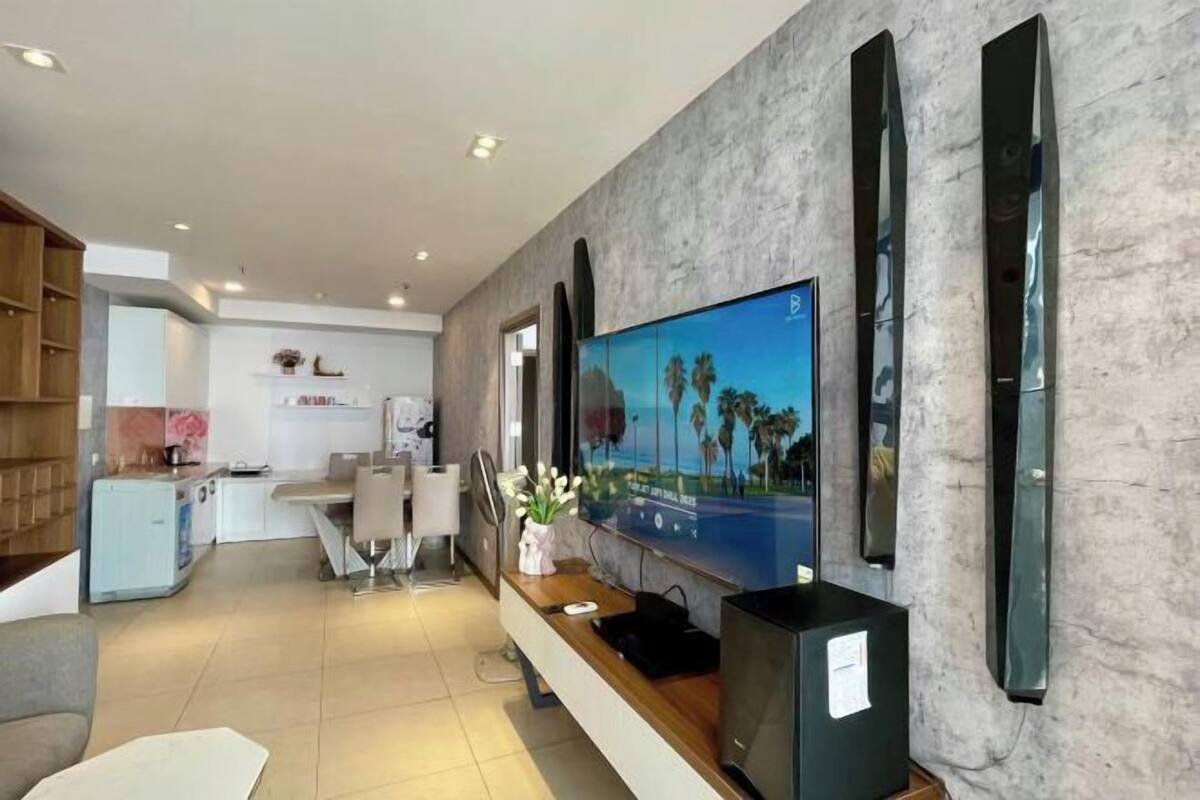 Eine moderne Hotellobby mit einem großen Flachbildfernseher, einer Rezeption und einer Sitzecke.