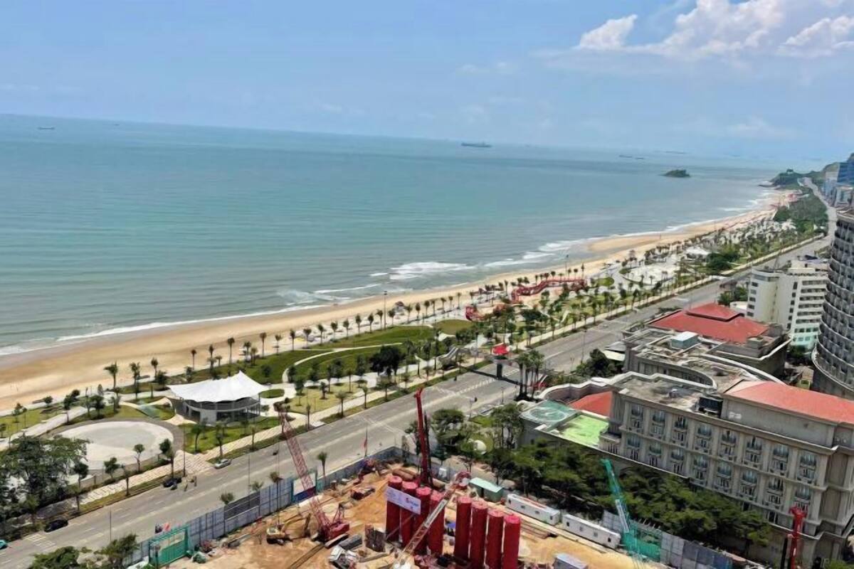 Ein Küstenhotel mit Blick auf den Strand, ein Kreisverkehr und eine Baustelle.