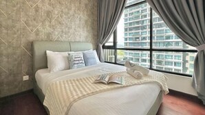 A hotel room with a large bed, a window with curtains, a wall with a geometric pattern, and a view of a building outside. - Molek Regency By Stayrene (Plentong)