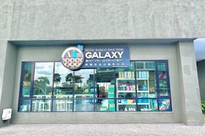 Un escaparate con un letrero que dice 'GALAXY' y un logotipo encima.