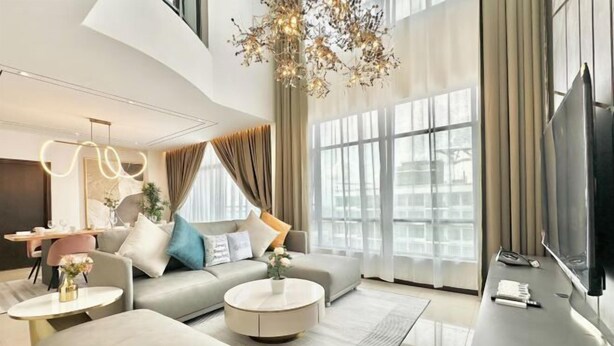 A modern living room with a sofa, coffee table, and TV. - Molek Regency By Stayrene (Plentong)