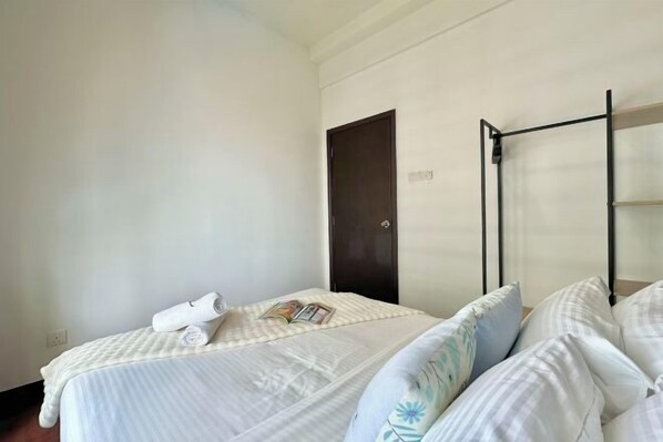 A hotel room with a bed, a wardrobe, and a small table with a magazine.
