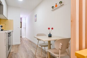 A modern kitchen with white cabinets, a wooden countertop, and a built-in oven. - ✨ Stylish & Bright Studio – Historic Center of Aix-en-Provence (Aix-En-Provence)