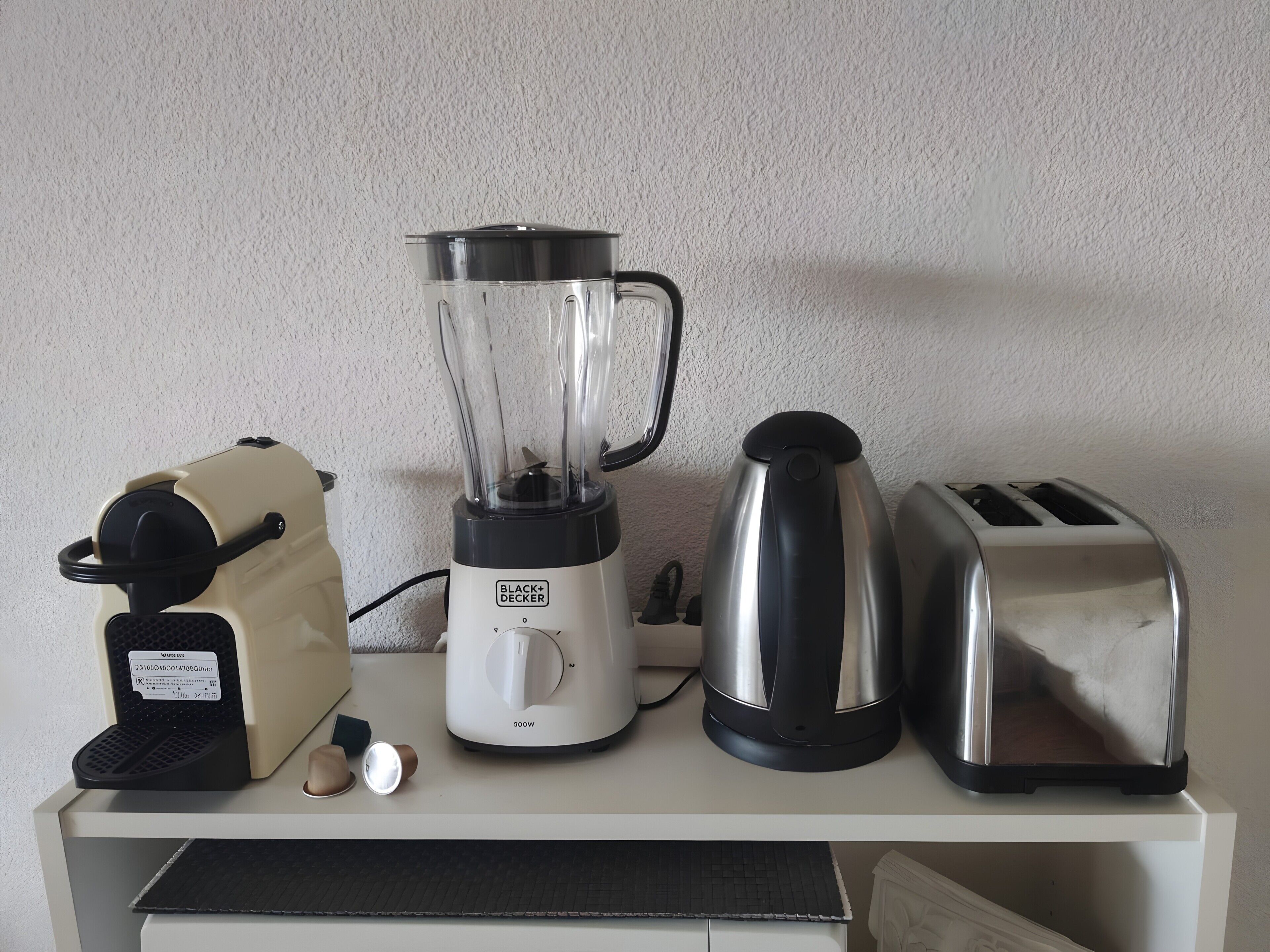 A kitchen counter with a blender, toaster, and coffee maker.