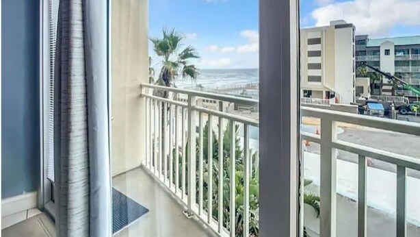 A balcony with a view of the ocean and a cityscape. - Charming apartment in serene Daytona Beach with AC (Daytona Beach)