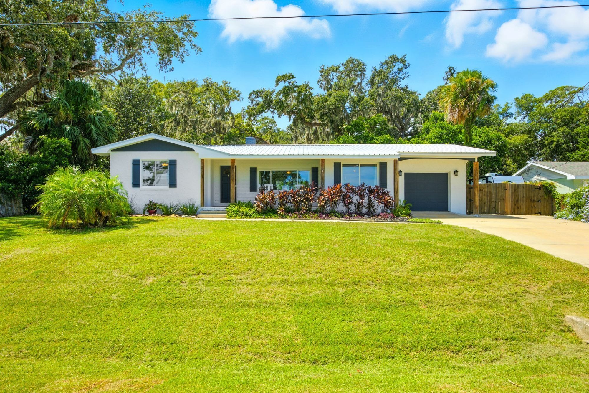A single-story house with a front porch, a garage, and a well-maintained lawn.
