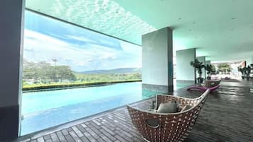 A modern indoor pool area with a view of a natural landscape.