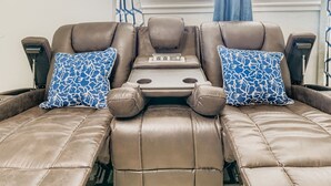 Una silla de masaje con panel de control y dos almohadones estampados.