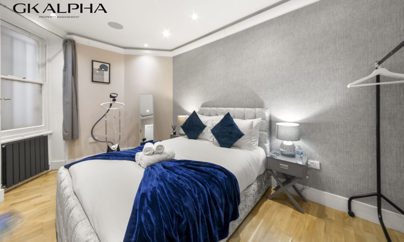 Une chambre d’hôtel moderne avec un grand lit, des tables de chevet, une armoire et une fenêtre.