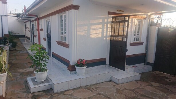 A building with a reception area, a door, and steps leading to a tiled entrance. - The Elegant Homes &Accommodation Kericho (Kericho)
