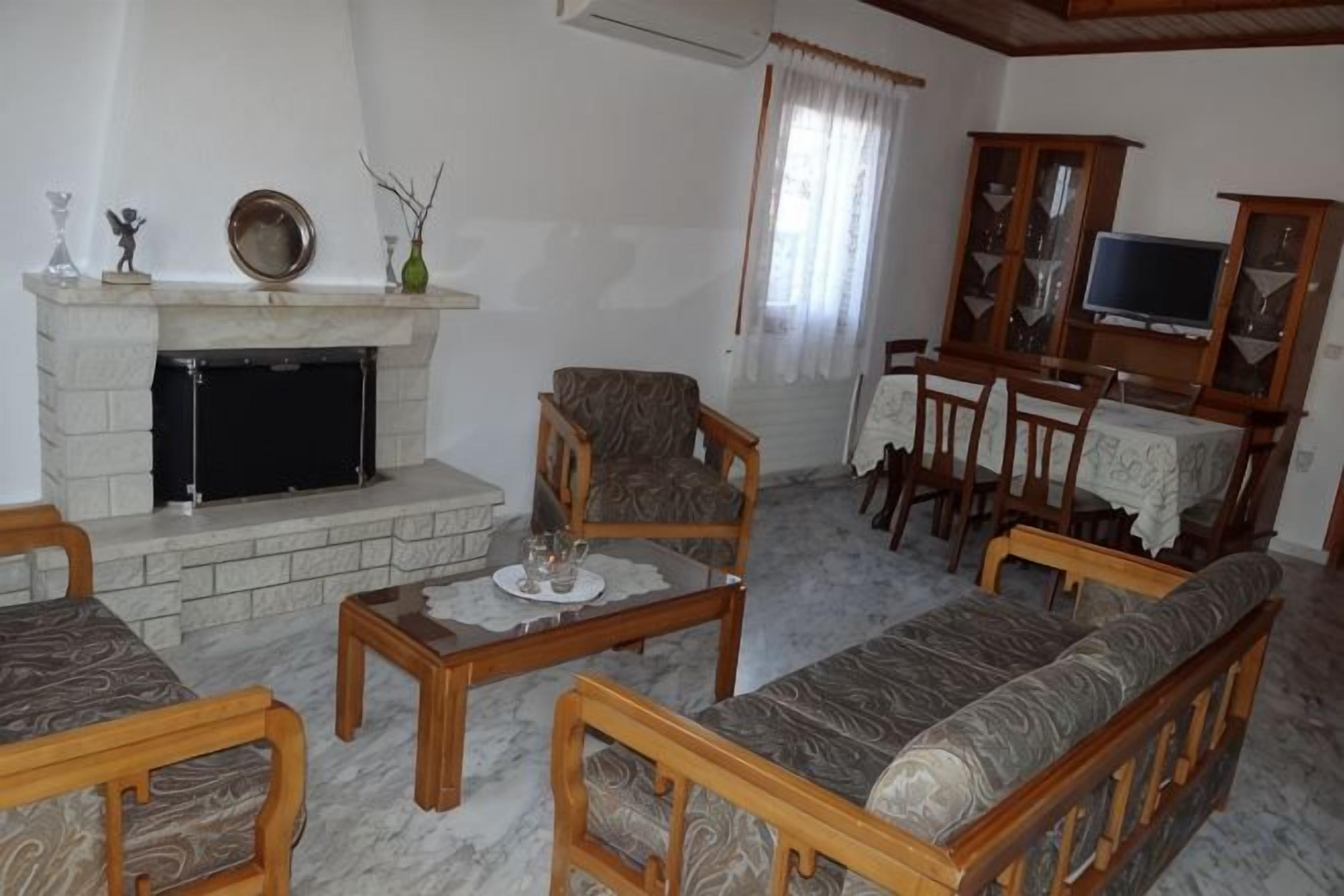 Una sala de estar con chimenea, muebles de madera y televisor.