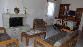 Una sala de estar con chimenea, muebles de madera y televisor.