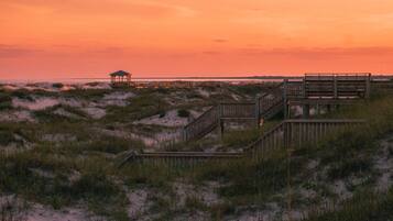 A wooden boardwalk leading to a gazebo over the dunes.