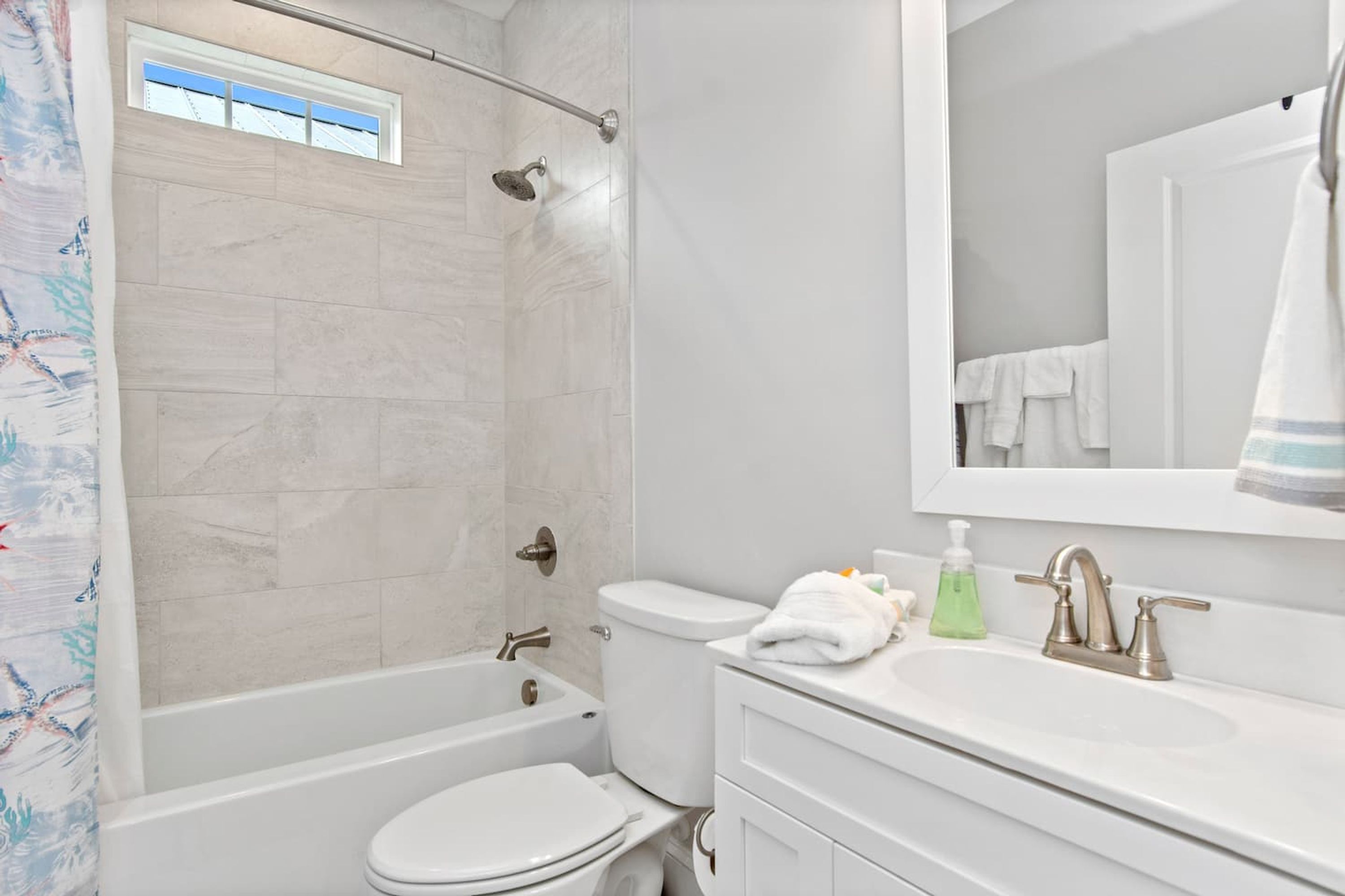 A modern bathroom with a bathtub, toilet, and sink.