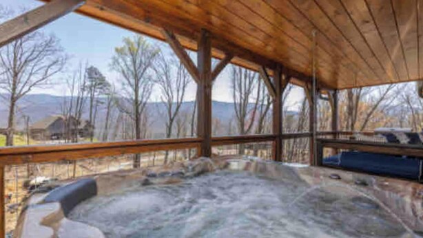 A hot tub area with a wooden ceiling and a view of the surrounding landscape. - Lux Cabin Smoky Mtn View Dog Friendly Hot Tub (Gatlinburg)