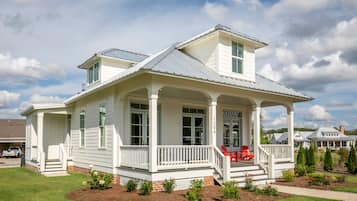 A two-story house with a porch, a garage, and a well-maintained lawn.
