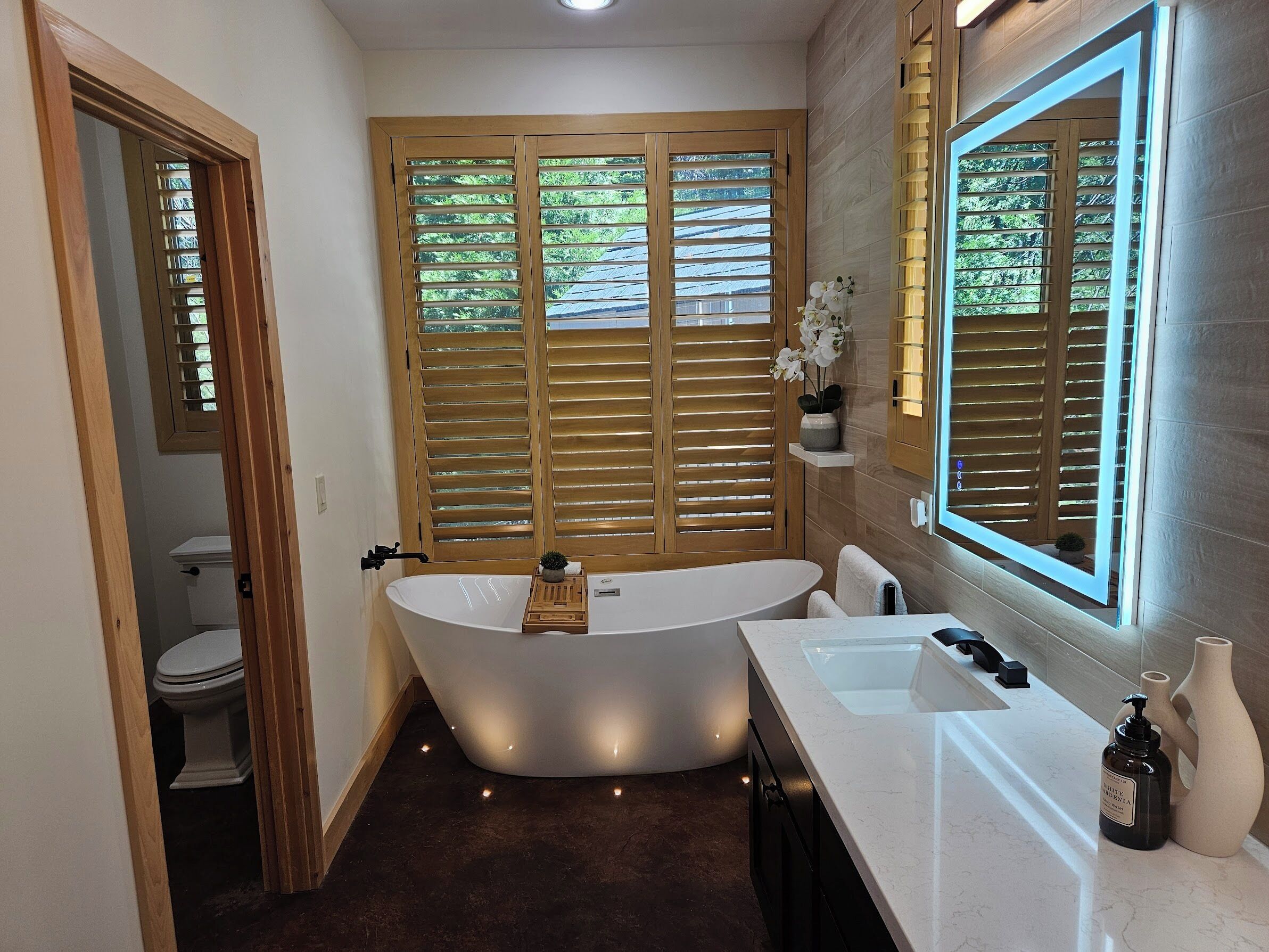 Une salle de bain moderne avec une baignoire sur pieds, un meuble-lavabo et un grand miroir.