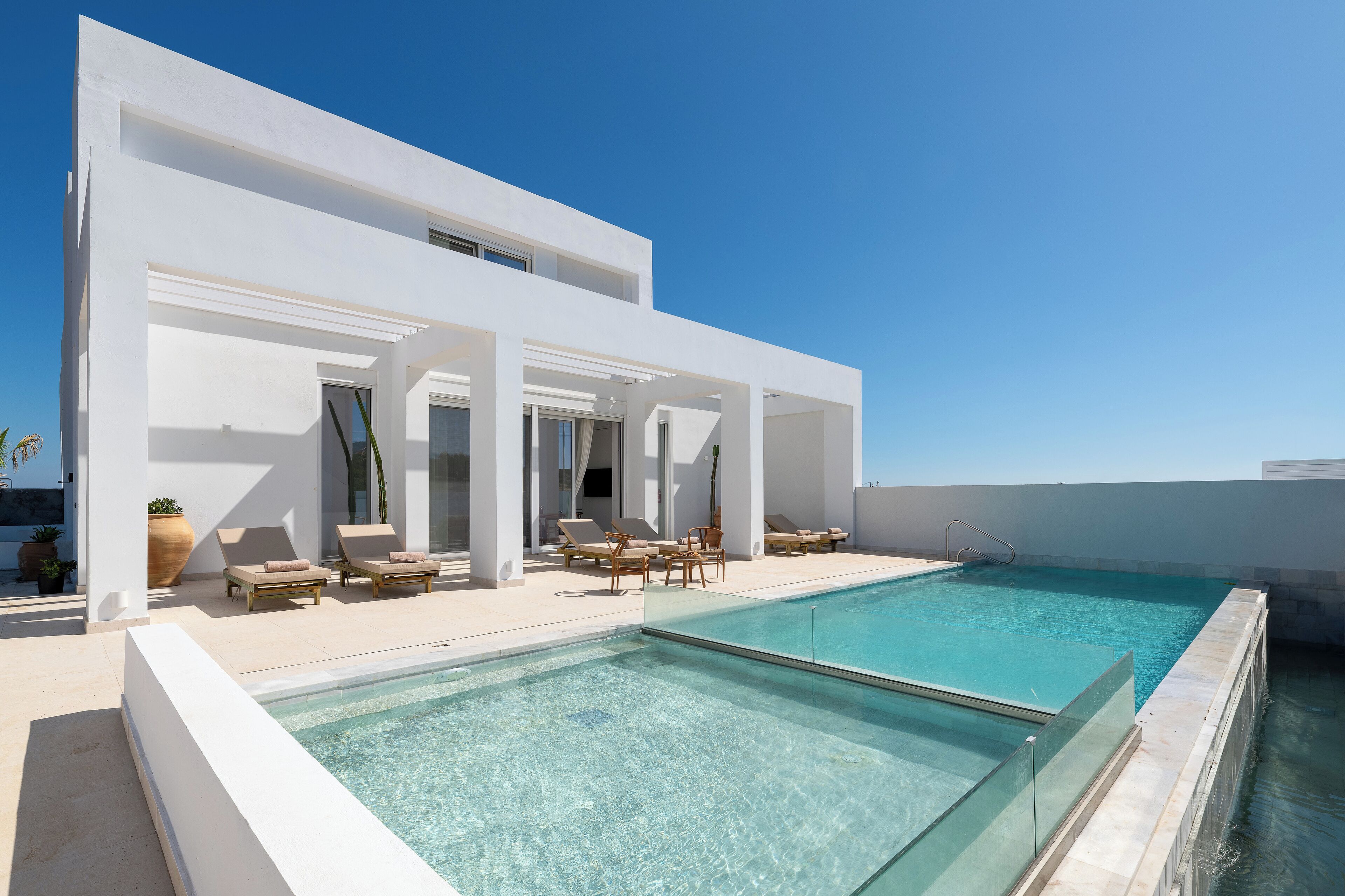 Een buitenzwembad, ligstoelen bij het zwembad