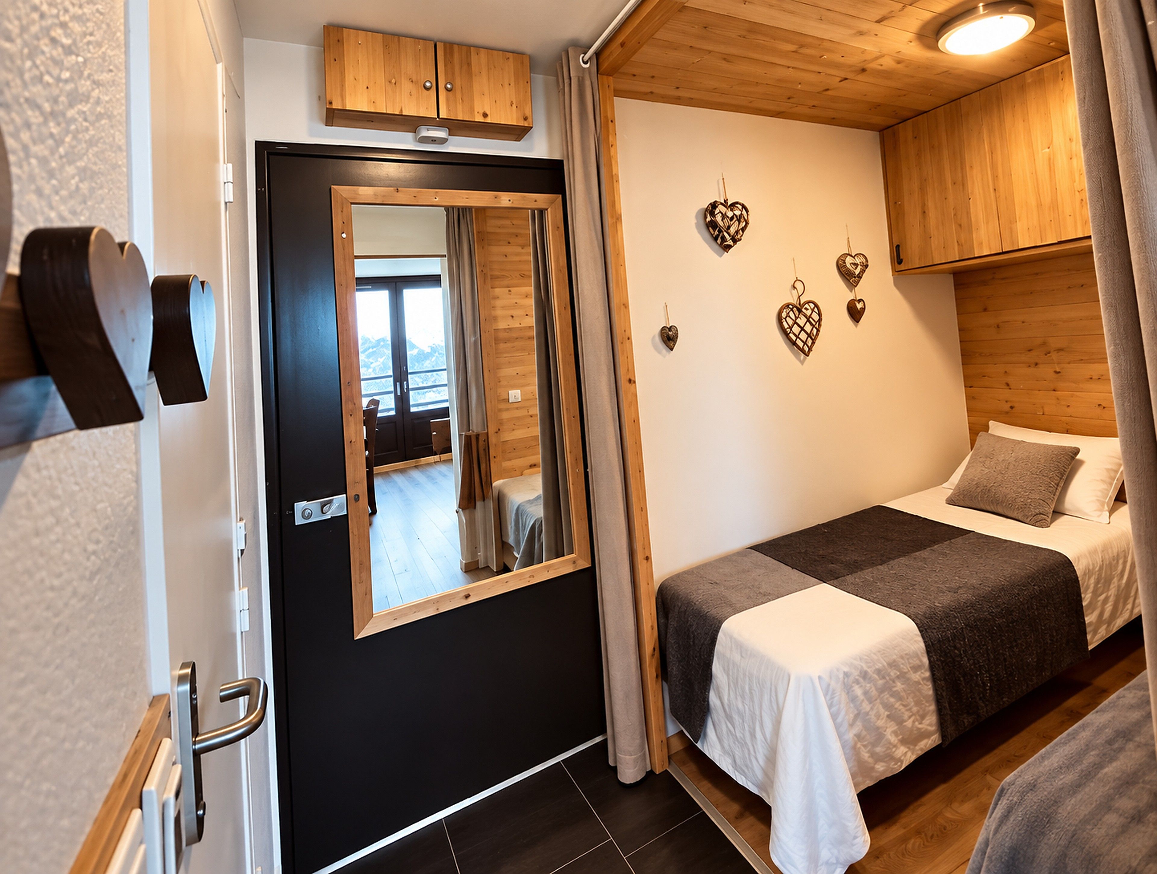 Un dormitorio con cama, espejo, armarios de madera y adornos con forma de corazón en la pared.