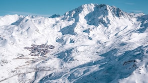 Un paisaje montañoso cubierto de nieve con un pueblo en el valle.